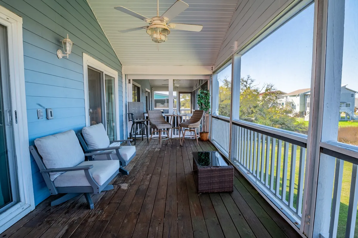 A tranquil outdoor space with comfortable seating and a dining area overlooking lush coastal landscaping, ideal for relaxing, dining al fresco, or enjoying sunset views after a day at the beach.